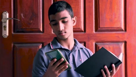 Teenager Boy Using Smartphone While Reading a Book. Stock Footage 170712861