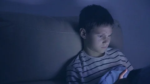 Teenager boy using tablet pc at home at night Stock Footage 128031814