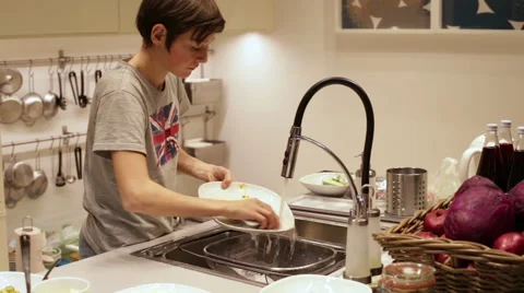 Teenager Boy Washing Dishes in the Sink Stock Footage