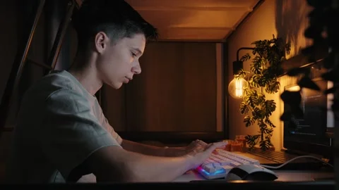 Teenager Coding on Computer in Dimly Lit Bedroom at Night 库存影片 344967830