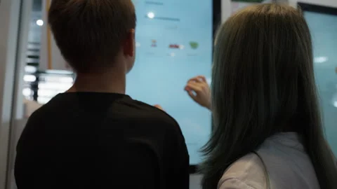 Teenager couple using interactive touchscreen self-service kiosk at fast fo.. Video stock 319582095