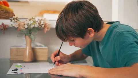 Teenager developing creativity and motor skills through painting. Artistic .. Stock Footage 327980341