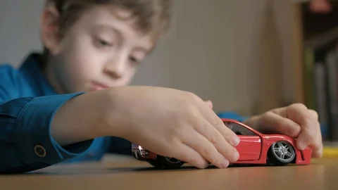 Teenager disassembling his red model supercar. Use screwdriver to unscrew cogs Stock Footage 129401795
