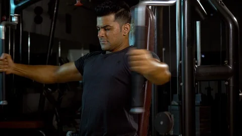 A teenager doing chest exercise on a machine at a home gym to stay fit Stock Footage 116307838