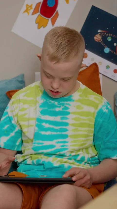 Teenager with down Syndrome Using Digital Tablet for Learning Stock Footage 337563885