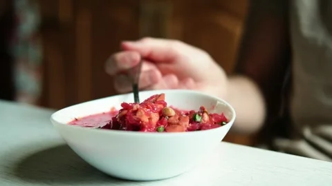 A teenager eats borscht soup sitting at the table in the kitchen. Stock Footage 282960595