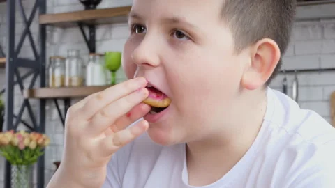 Teenager eats junk food while working at home. Attractive plump handsome young Stock Footage 232883388