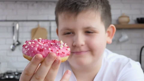 Teenager eats junk food while working at home. Attractive plump handsome young Stock Footage 233381553