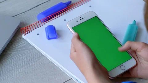 Teenager hands using smartphone empty green screen top view 库存影片 129536266