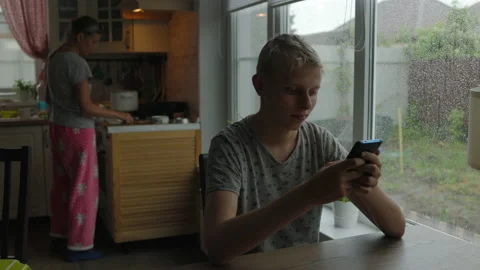 Teenager At Home At Table On Background Of Window Communicates By Video Chat Stockbeeldmateriaal 154648581