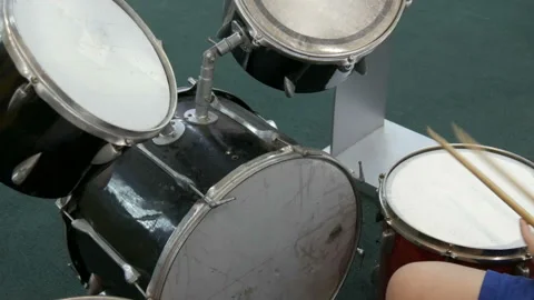 The teenager is learning to play drum set. Drum sticks knock on different drums Stock Footage 105469905