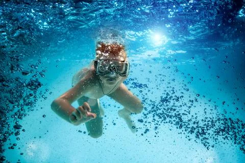 Teenager in the mask and snorkel swim underwater. Stock Photos