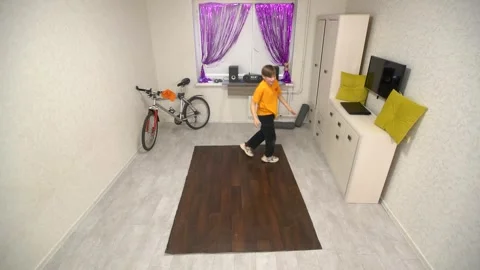 The teenager performs dance movements in a small room with a modern bicycle Stock Footage 311012761