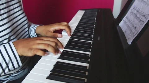 Teenager playing on a eletronic keyboard Stock Footage 79312959
