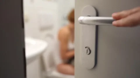 Teenager is seen using smartphone through opening bathroom door Stock Footage 251633305