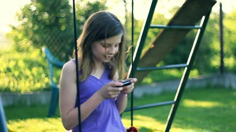 Teenager sending sms, texting on the swing, slow motion HD Stock Footage