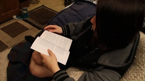 Teenager sitting on sofa, reading Stock Footage 79046845