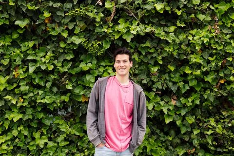 Teenager smiling on a green plants background Stock Photos