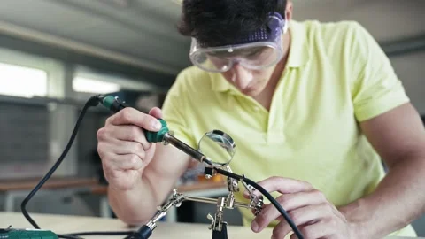 Teenager Student soldering electronics cable, learning engineering and Stock Footage 238477953