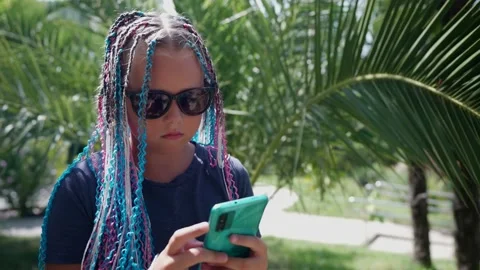 A teenager is typing a text message using a smartphone. A beautiful girl with Видео 160025169