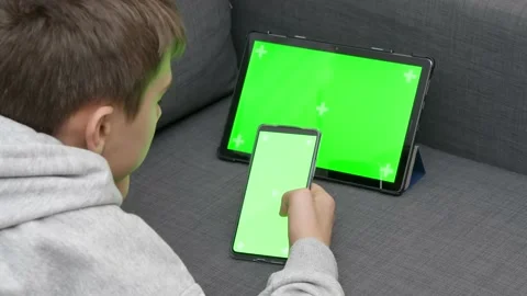Teenager using multiple electronic internet devices in same time. Boy watching Stock Footage 170320636