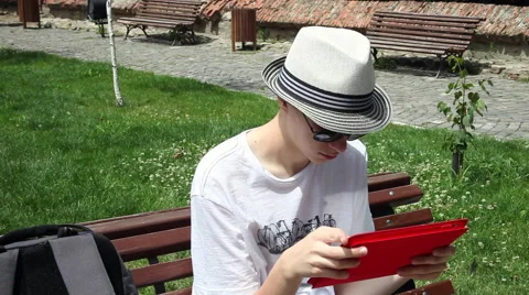 Teenager using tablet computer, bench, park, summer Stock Footage 44894670