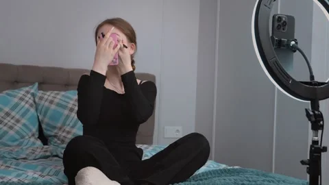 Teenager vlogger applying makeup while recording a tutorial Stock Footage 311779808