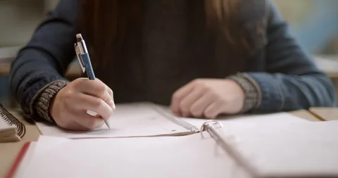 Teenager writes in notebook while taking online class Vídeos de archivo 118141183