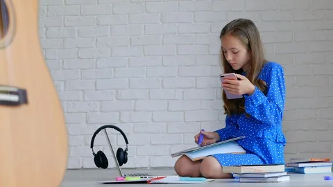 Teenager writing down email notes from phone. 库存影片 129536246