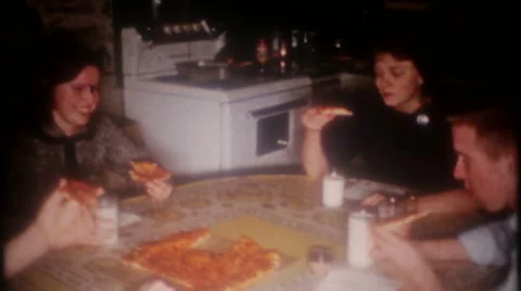 Teenagers around kitchen table eating pizza 1950s vintage film home movie 3701 Stock Footage