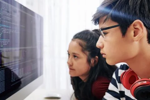 Teenagers examining programming code computer screen Stock Photos