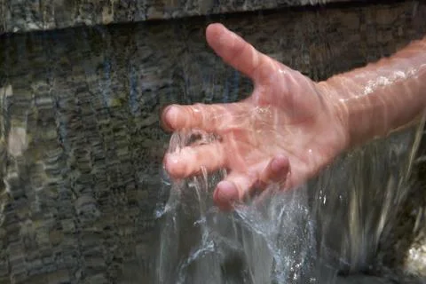 Teenager's hand under cascade of running water Stock Photos