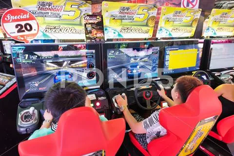 Teenagers play in amusement arcade, Bangkok Stock Photos