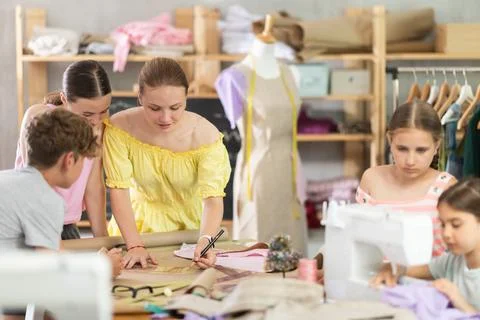Teenagers practicing pattern drafting during sewing course Stock Photos