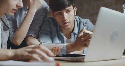 Teenagers studying together using tablet and laptop, preparing for test Stock-Footage 92996093