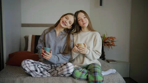 Teenagers take a break at home while drinking from cups and enjoying each other' Stock Footage 338052431
