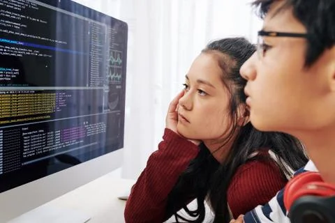 Teenages examining programming code Foto stock