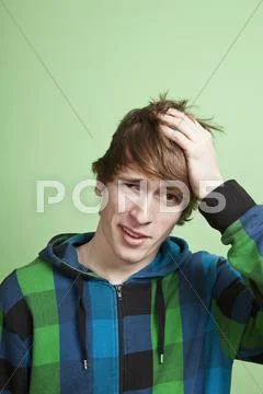 A teenboy looking embarrassed, portrait, studio shot Stock Photos
