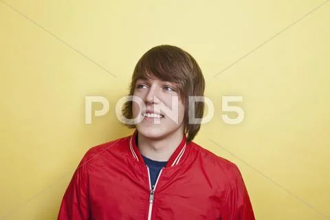 A teenboy looking off to the side and laughing, portrait, studio shot Stock Photos