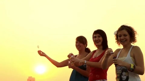 Teens blow bubbles at sunset. Stock-Footage 7769307