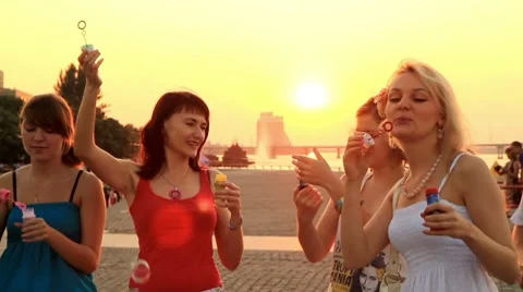 Teens blow bubbles at sunset. Stock Footage 7769336