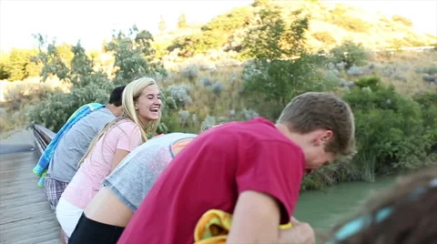 Teens Climb On Bridge, To Look At River Below, They Are Excited To Go Swimming Video stock 47496128