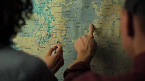 Teens exploring a map to plan a summer adventure in the Pacific Northwest Stock Footage 323928044