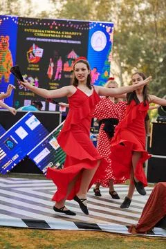 Teens female dance group in red dresses dance on outdoor dancing floor at c.. Stock Photos
