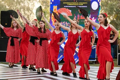 Teens female dance group in red dresses dance on outdoor dancing floor at c.. Stock Photos