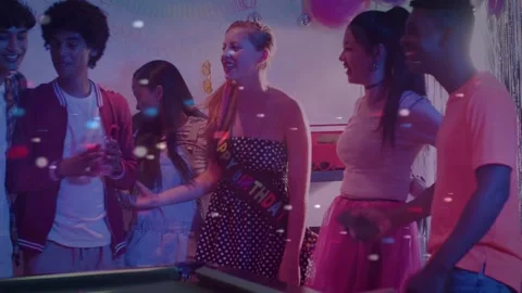Teens gathering around pool table for event, handshake sparking birthday Stock Footage 333999835