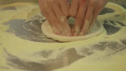 Teen's hands roll dough for pizza. Fresh flour scattered on table Stock Footage 76901514