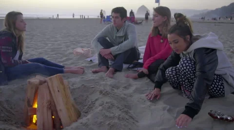 Teens hang out by fire Stock Footage 53232921