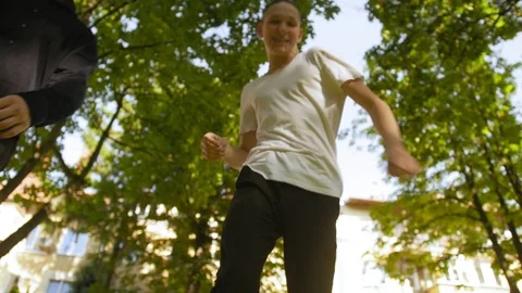 Teens kick a guy. View from below. Teens fighting, conflict, street violence 스톡 동영상 118701903