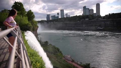 Teens peeking over the Niagara Falls Stock Footage
